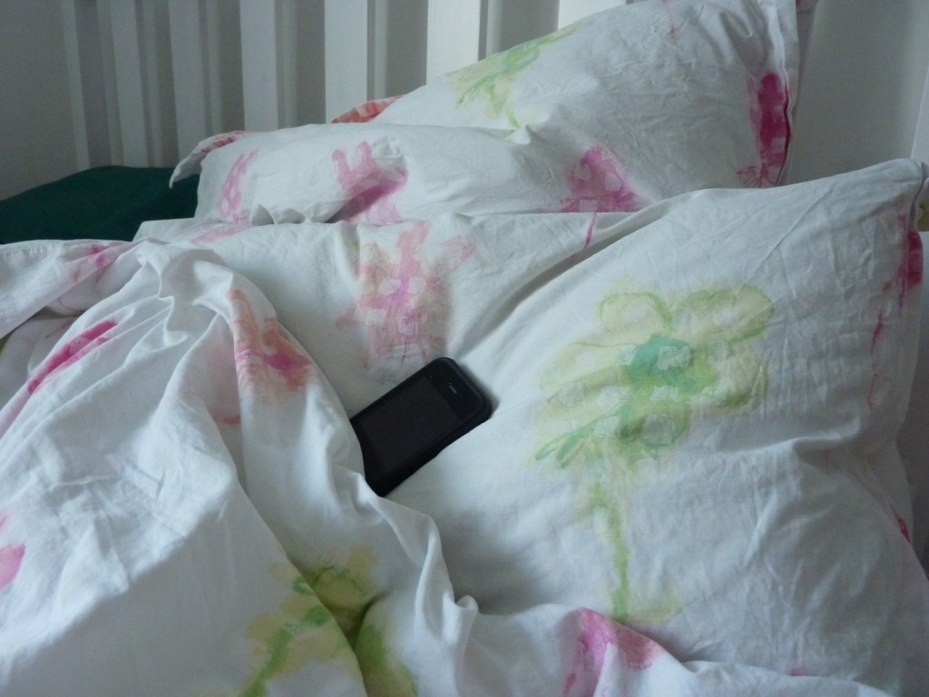 A smart phone on a pillow.