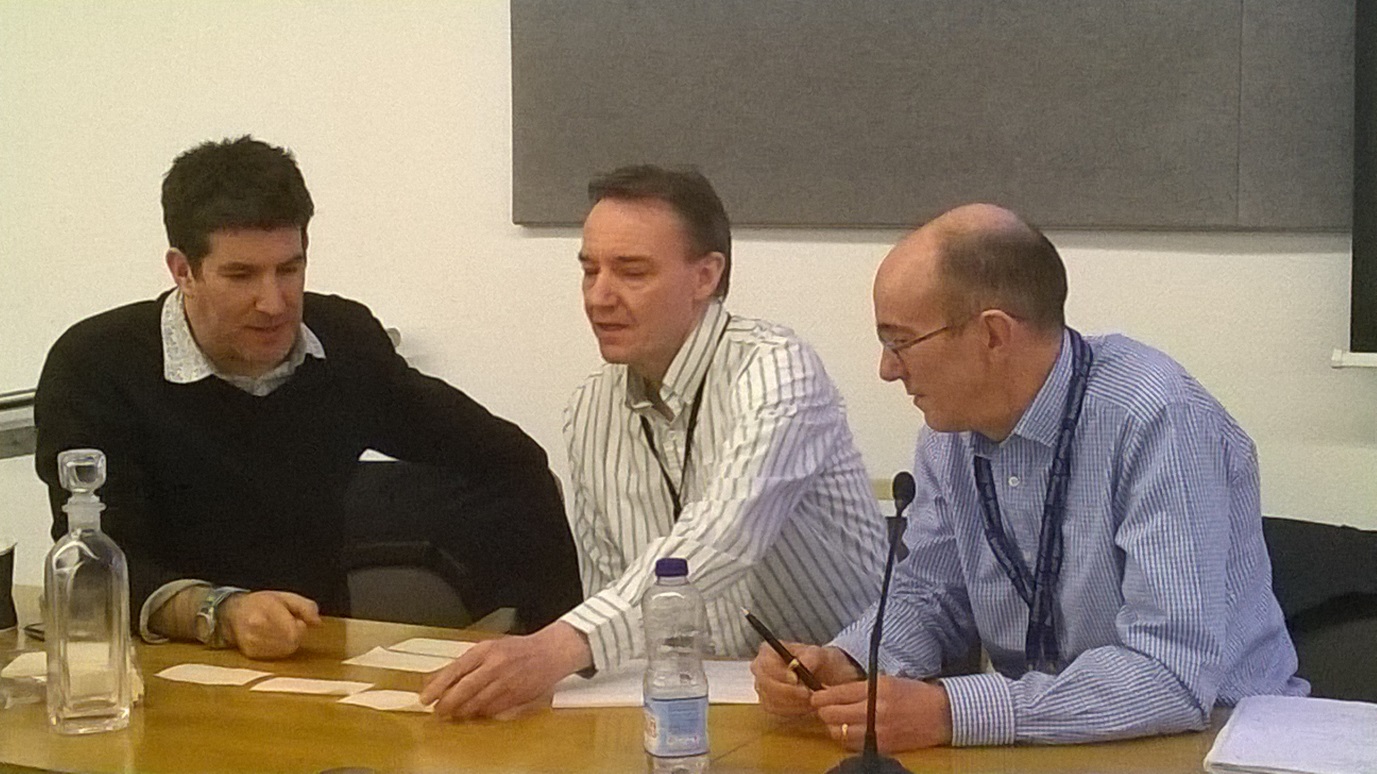 3 men sitting at a desk