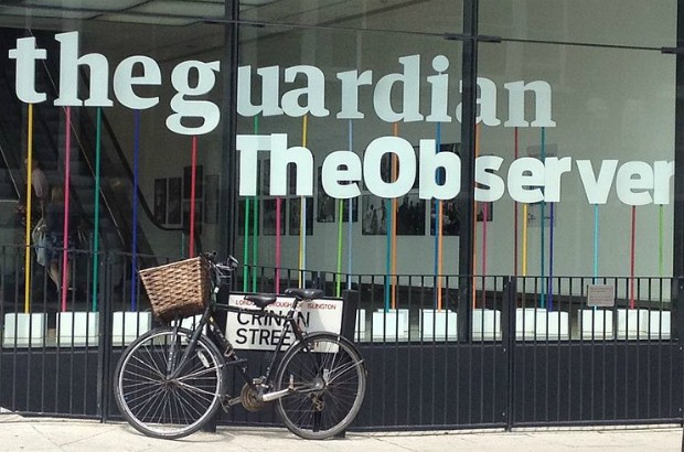 A bike leaning against the window of the The Guardian building.