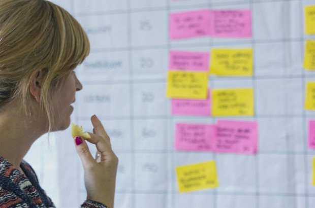 A woman looking at a schedule at CommsCamp.