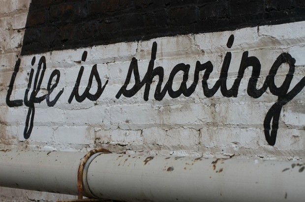 A mural on a brick wall saying 'Life is sharing'.